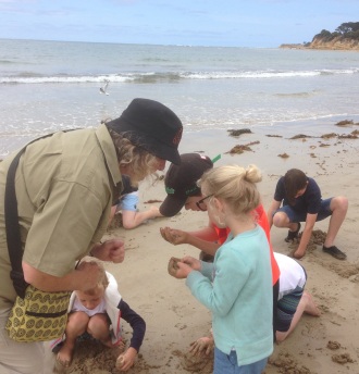 GORCC Education Activity Leader Hilary Bouma examines some of the treasures the Summer by the Sea participants found on the beach.